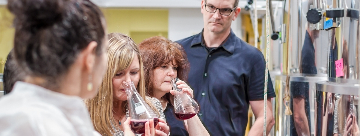 Northwest Wine Academy students smelling wine from a beaker 